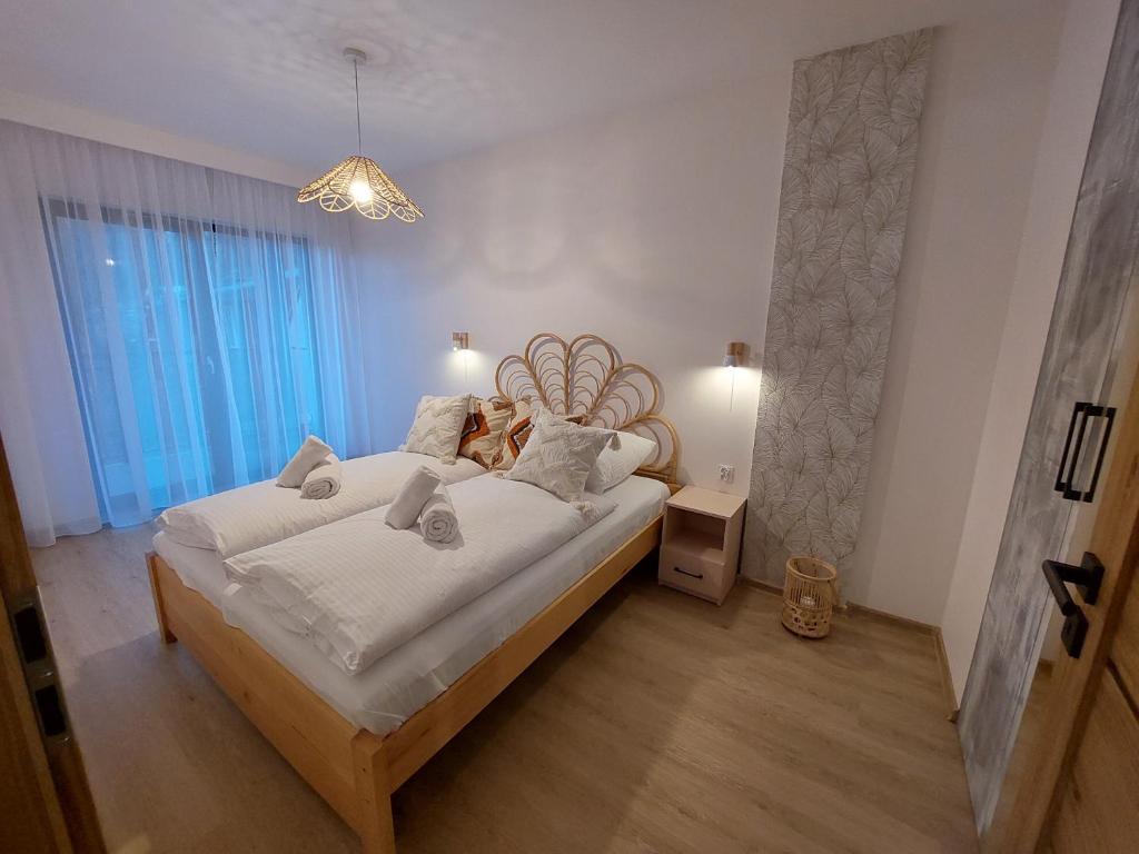 a bedroom with a large bed with white sheets at Apartament Pod Papugami 2 Karpatia Resort in Karpacz