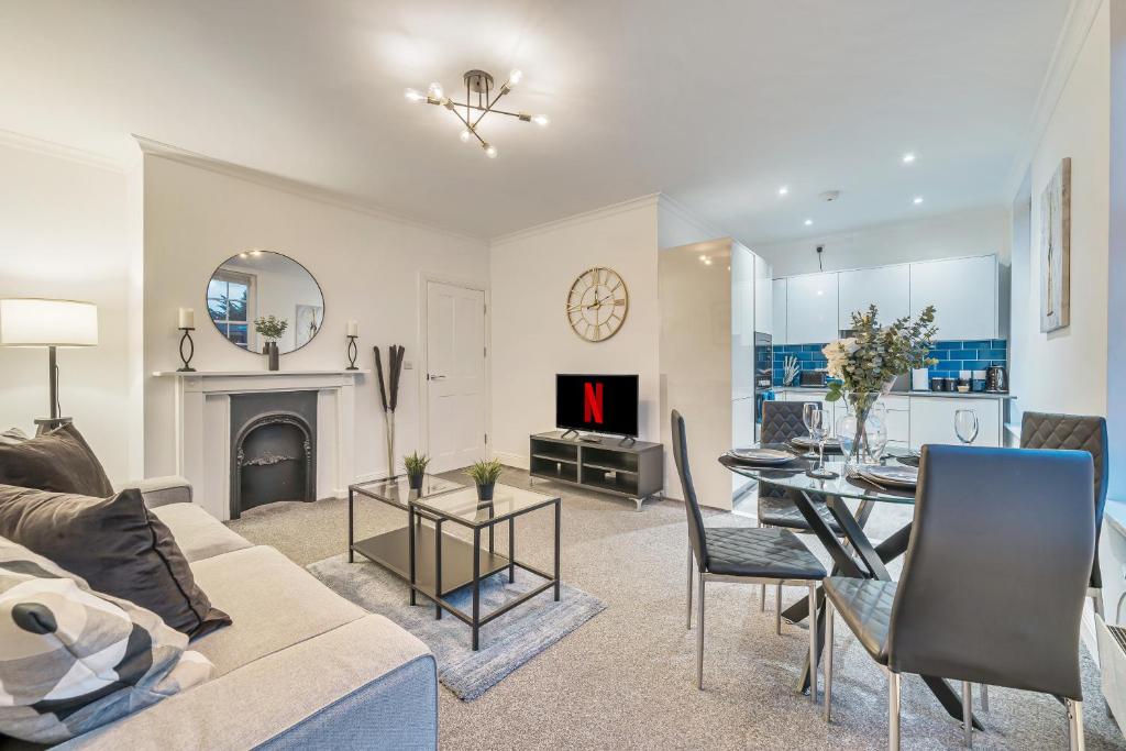a living room with a couch and a table and a fireplace at Modern, City Centre -2 Bedroom Apartments in Reading