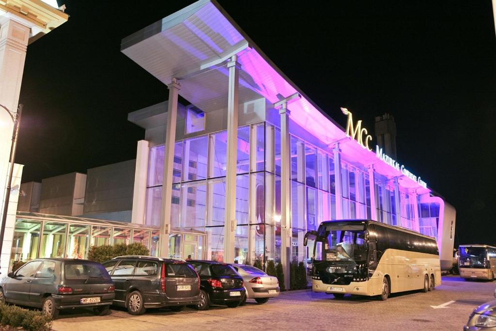 a building with cars parked in front of it at night at Hotel Mazurkas in Ożarów Mazowiecki