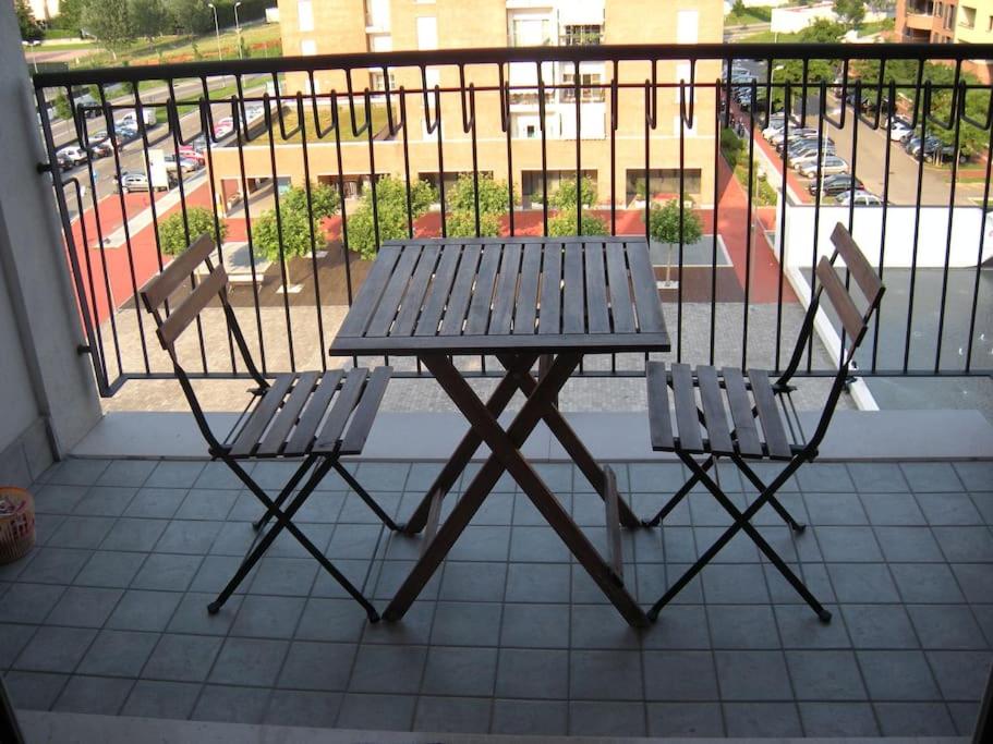 a picnic table and two chairs on a balcony at Rosaviola in Vimodrone