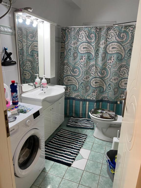 a bathroom with a washing machine and a toilet at Apartment Mitrou 2 in Loutra Oraias Elenis 