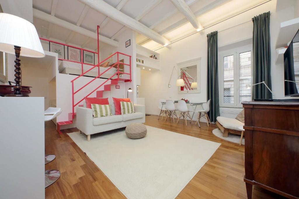 a living room with a red staircase and a couch at 4BNB - Serpenti Delightful Apartment in Rome