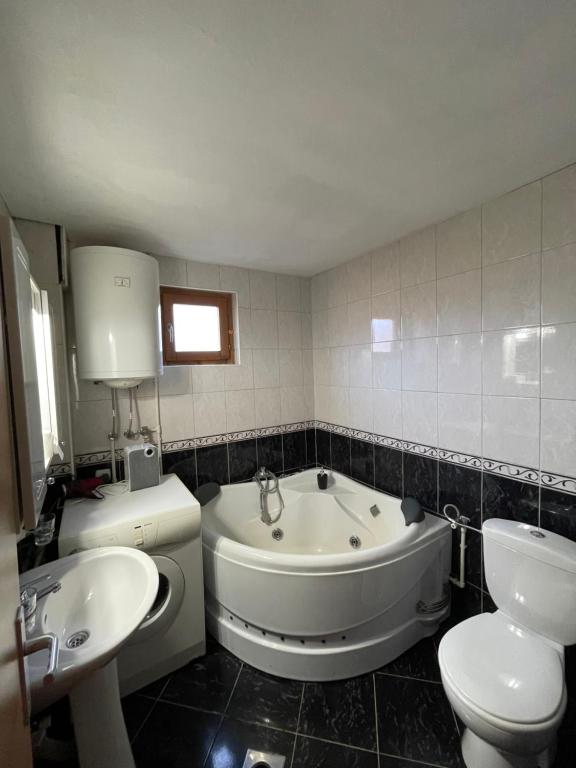 ein Badezimmer mit einer Badewanne, einem WC und einem Waschbecken in der Unterkunft Chalet Breza in Kolašin