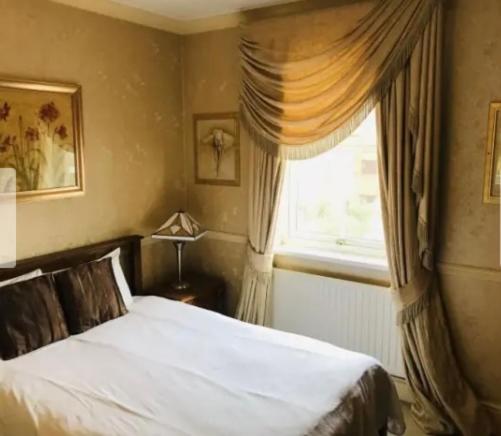 a bedroom with a white bed and a window at The York Hotel in Wolverhampton