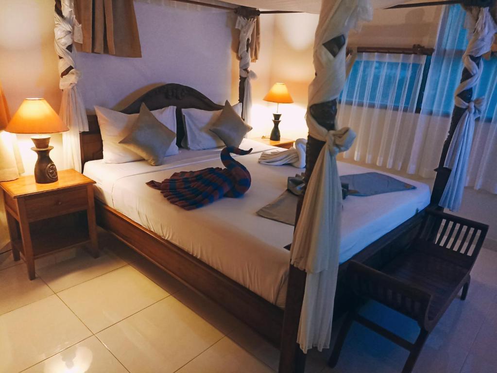 فندق Kusnadi في ليغِيان: غرفة نوم بسرير وكرسي ومصباحين