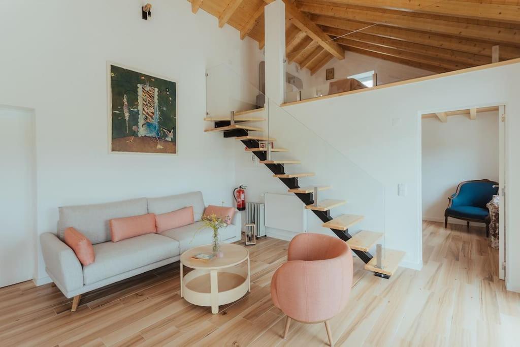 sala de estar con sofá y escalera de caracol en Apartamento Alicante, en Montemor-o-Novo