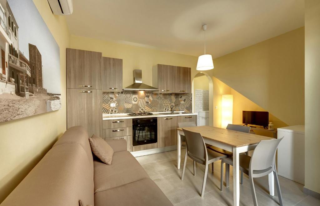 eine Küche und ein Esszimmer mit einem Sofa und einem Tisch in der Unterkunft Bilocale a 2 passi dal mare di Montalbano in Punta Secca