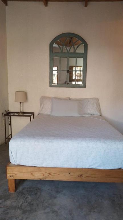 una camera da letto con un grande letto con uno specchio sul muro di Casa de Kai Mazunte a Mazunte
