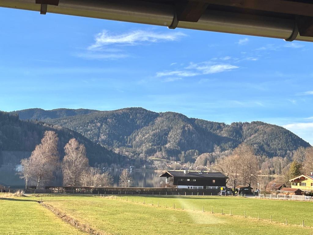 een uitzicht op een boerderij met een berg op de achtergrond bij Hohenwaldeck Seeblickrefugium in Schliersee