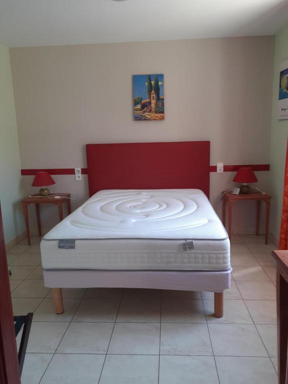 Bett in einem Zimmer mit 2 Lampen an Tischen in der Unterkunft Gîte La Jaubertie Labellisé Handicap in Meyrals