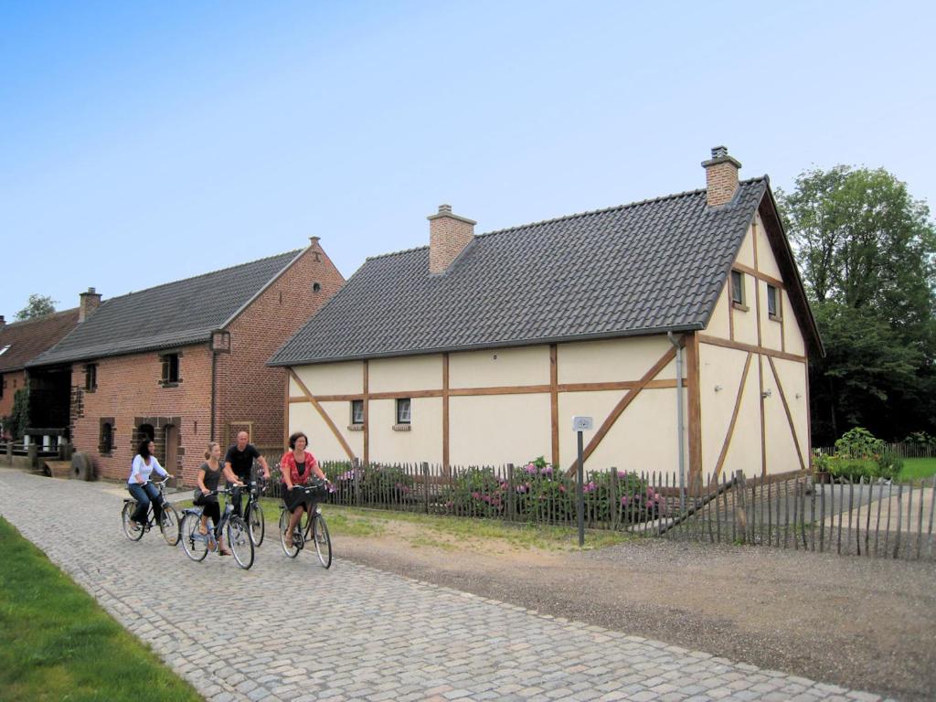 3 personnes à vélo devant un bâtiment dans l'établissement De Kleen Meulen - max 6pers, à Lummen