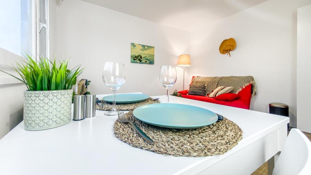 a living room with a table with plates and wine glasses at Homey AWAY - Centre-ville &#47; Au Calme &#47; Proche des transports pour Genève in Annemasse