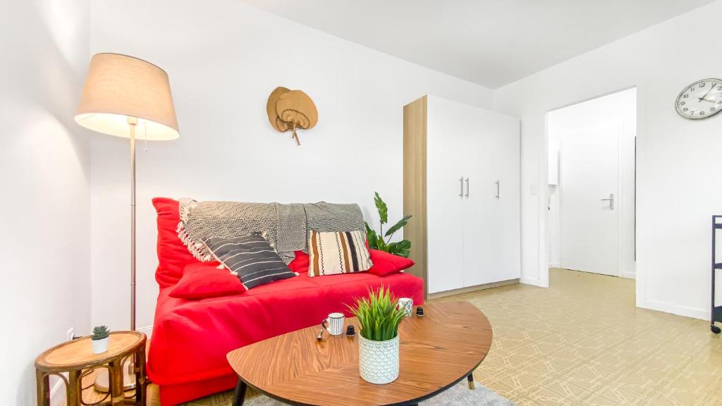a living room with a red couch and a table at Homey AWAY - Centre-ville &#47; Au Calme &#47; Proche des transports pour Genève in Annemasse