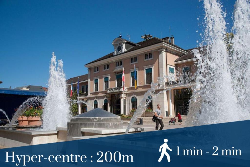 a man standing in front of a fountain in front of a building at Homey AWAY - Centre-ville &#47; Au Calme &#47; Proche des transports pour Genève in Annemasse
