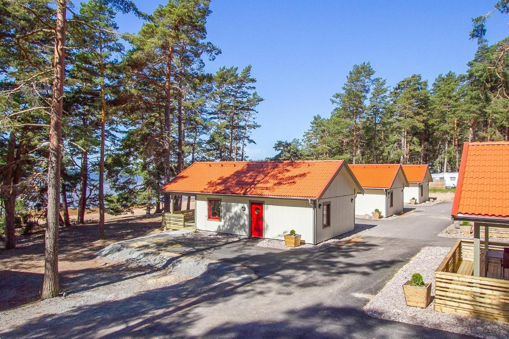 una pequeña casa con techo naranja en una calle en Karlstad Swecamp Bomstadbaden en Karlstad