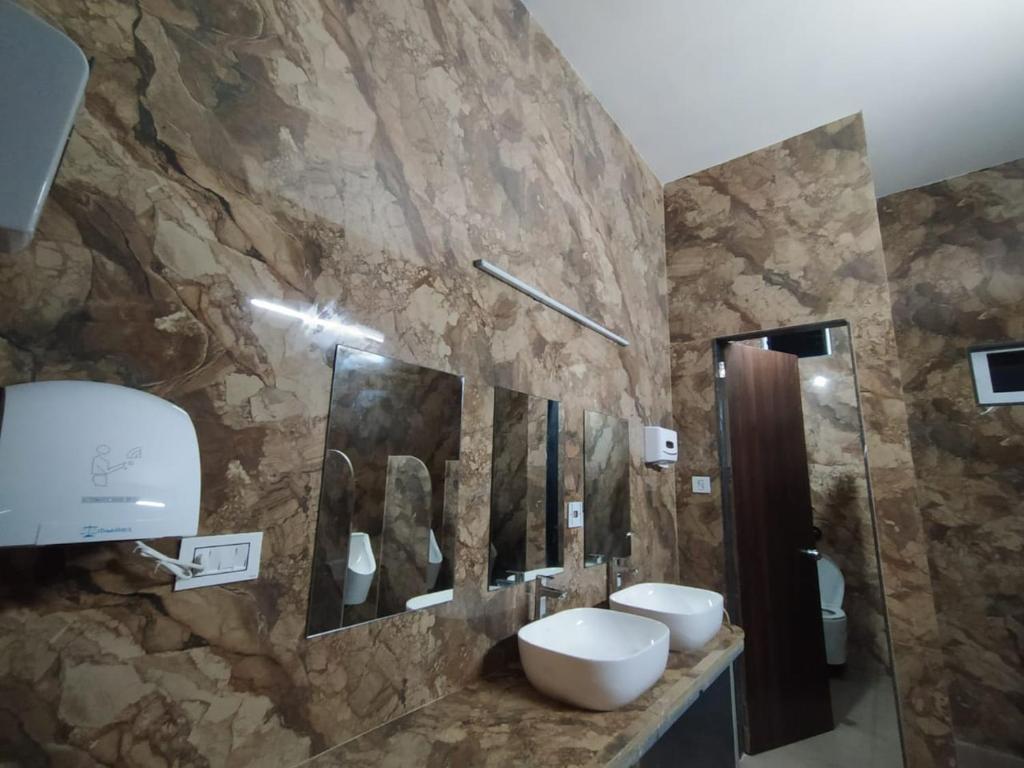 a bathroom with two sinks and a stone wall at Flamingo Club and Resort Una 3 Km Away from Diu Check Post in Diu