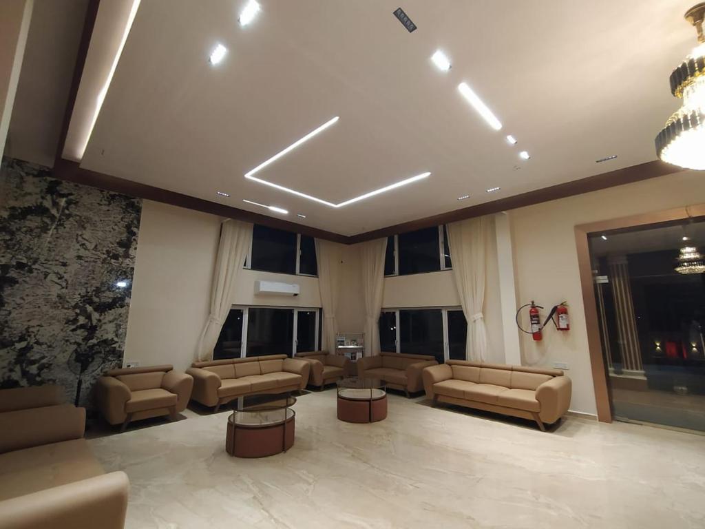 a waiting room with couches and tables and windows at Flamingo Club and Resort Una 3 Km Away from Diu Check Post in Diu