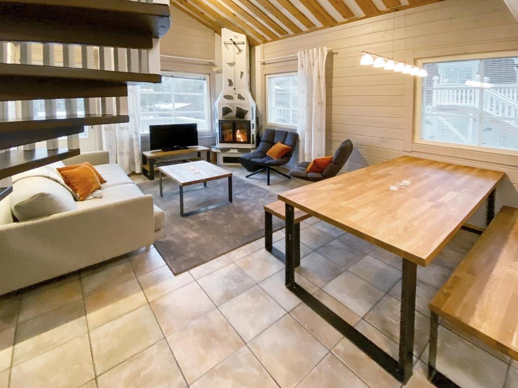 uma sala de estar com uma mesa e um sofá em Levin Alppitalot Alpine Chalets em Levi