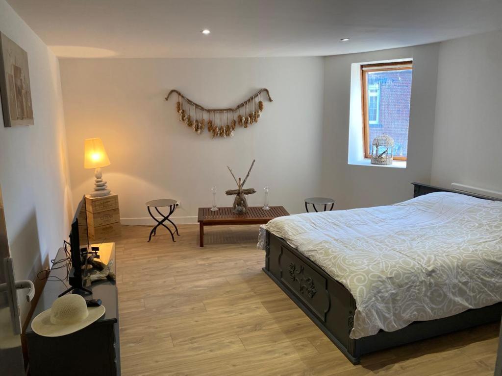 Schlafzimmer mit einem Bett, einem Tisch und einem Fenster in der Unterkunft studio naturel in Arras