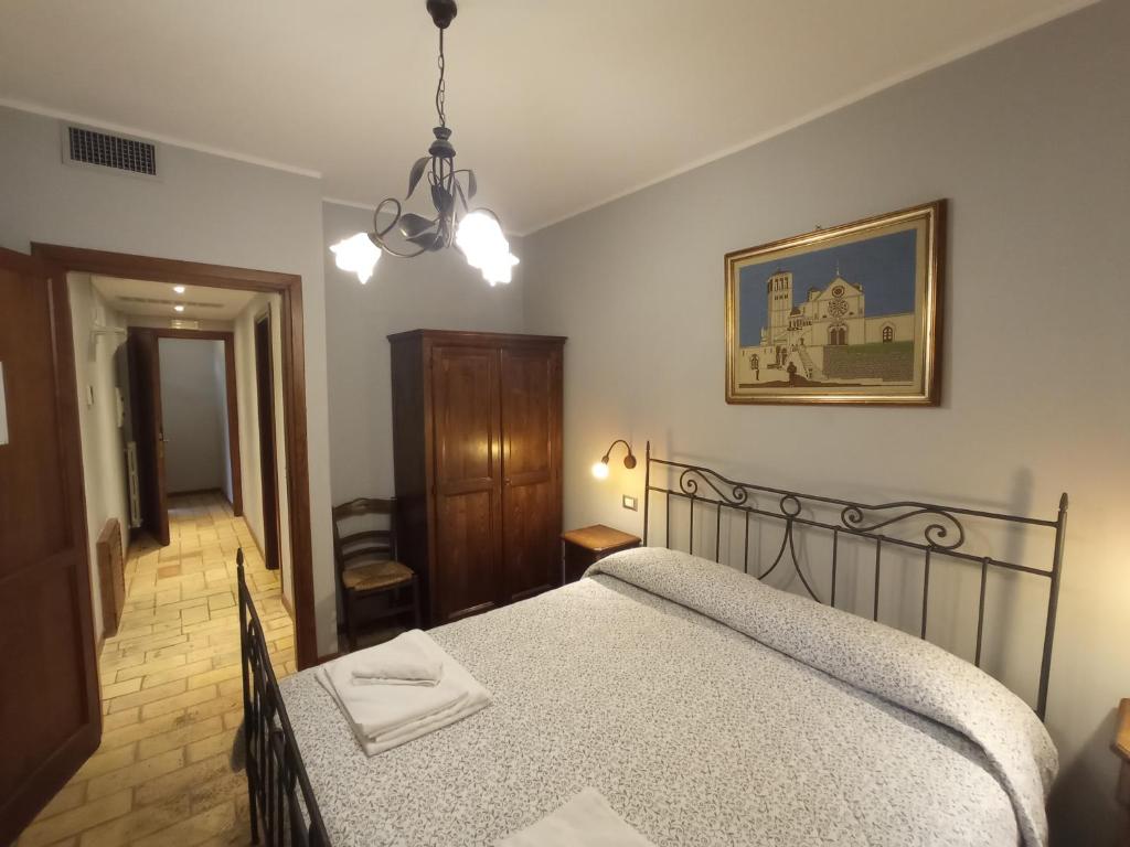 - une chambre avec un lit et une photo sur le mur dans l'établissement All'Ombra di San Damiano, à Assise