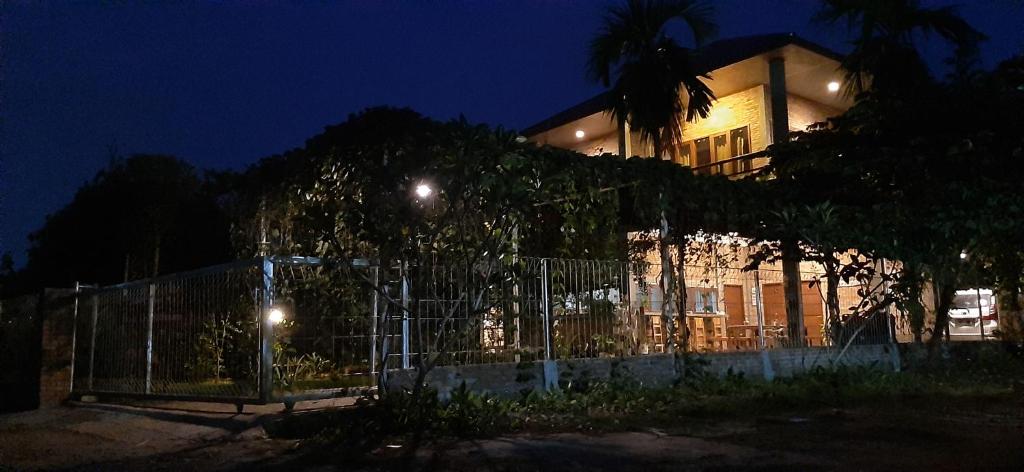 a building with a fence in front of it at night at Bua Guest House in Medan