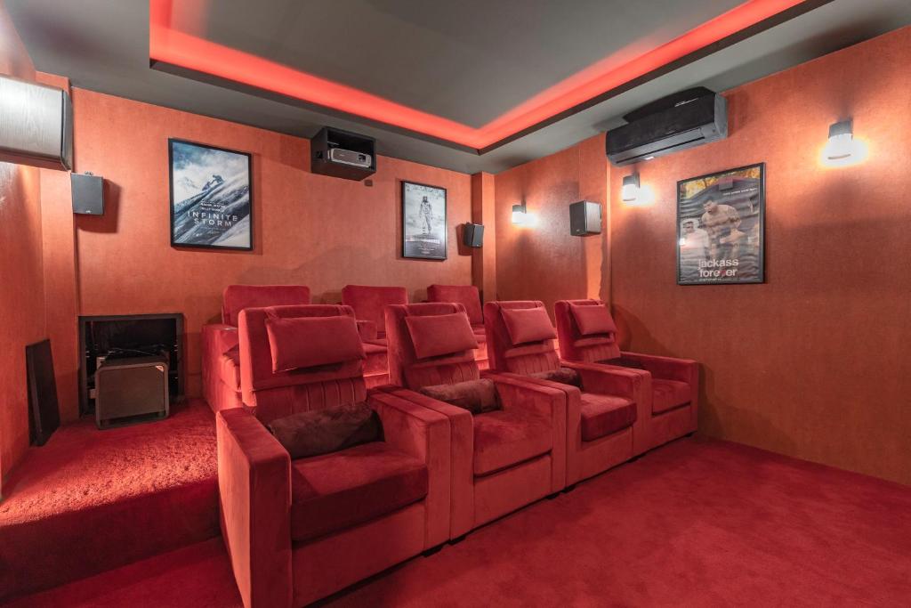 une salle de cinéma avec des chaises rouges et une cheminée dans l'établissement Palm Villa - Award Winning Modern Luxury & Exclusive Villa Resort, à Chiang Mai