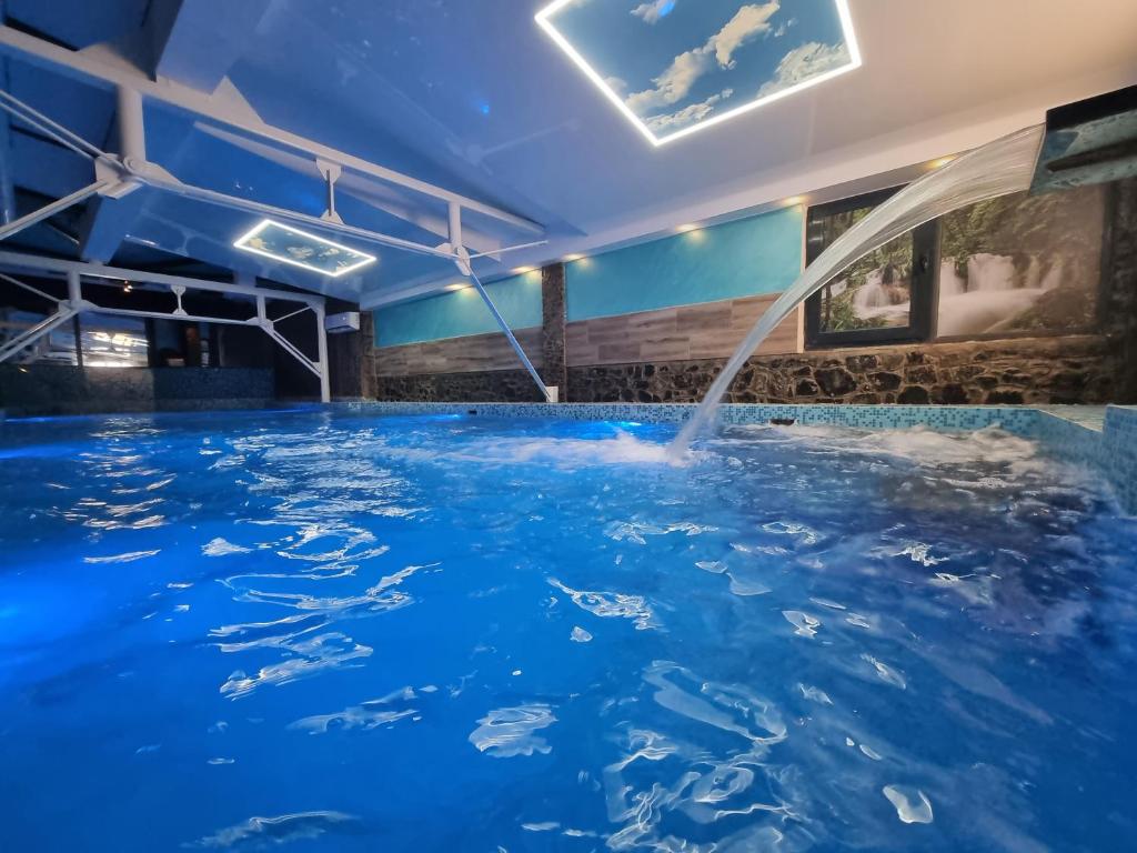 a pool of blue water with a fountain at Club Satelit Zlatibor in Zlatibor