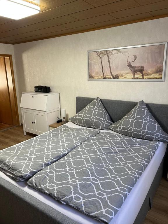 - une chambre avec un lit et une photo de cerf sur le mur dans l'établissement Bergmannsruh, à Clausthal-Zellerfeld