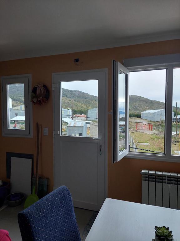 Habitación con 3 ventanas y puerta blanca en B&B Akar en Ushuaia