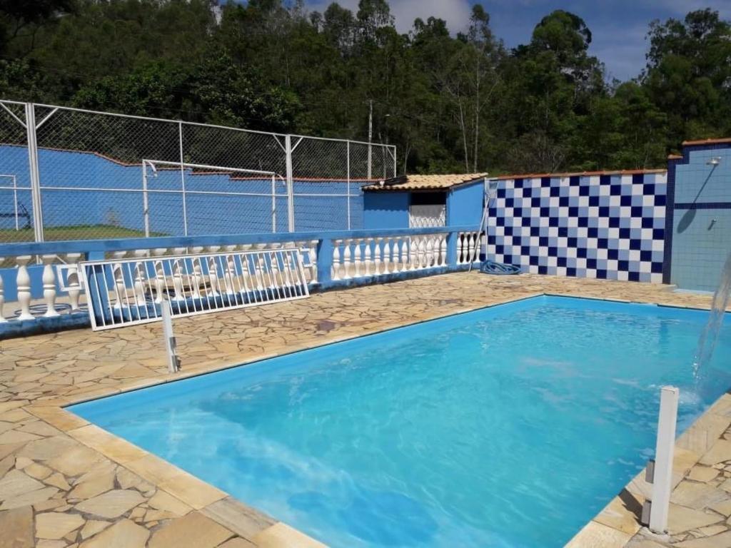 uma grande piscina azul com cerca em Chacara dos sonhos em São José dos Campos