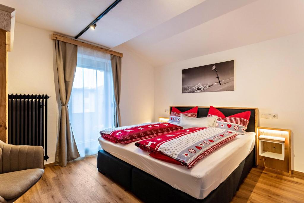 ein Schlafzimmer mit einem großen Bett mit roten Kissen in der Unterkunft Bergwelt A2 in Niederau