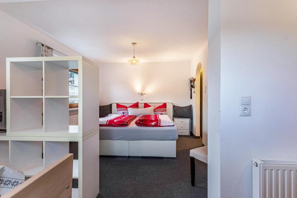 ein Schlafzimmer mit einem Bett mit roten Kissen in der Unterkunft Bergwelt C in Niederau