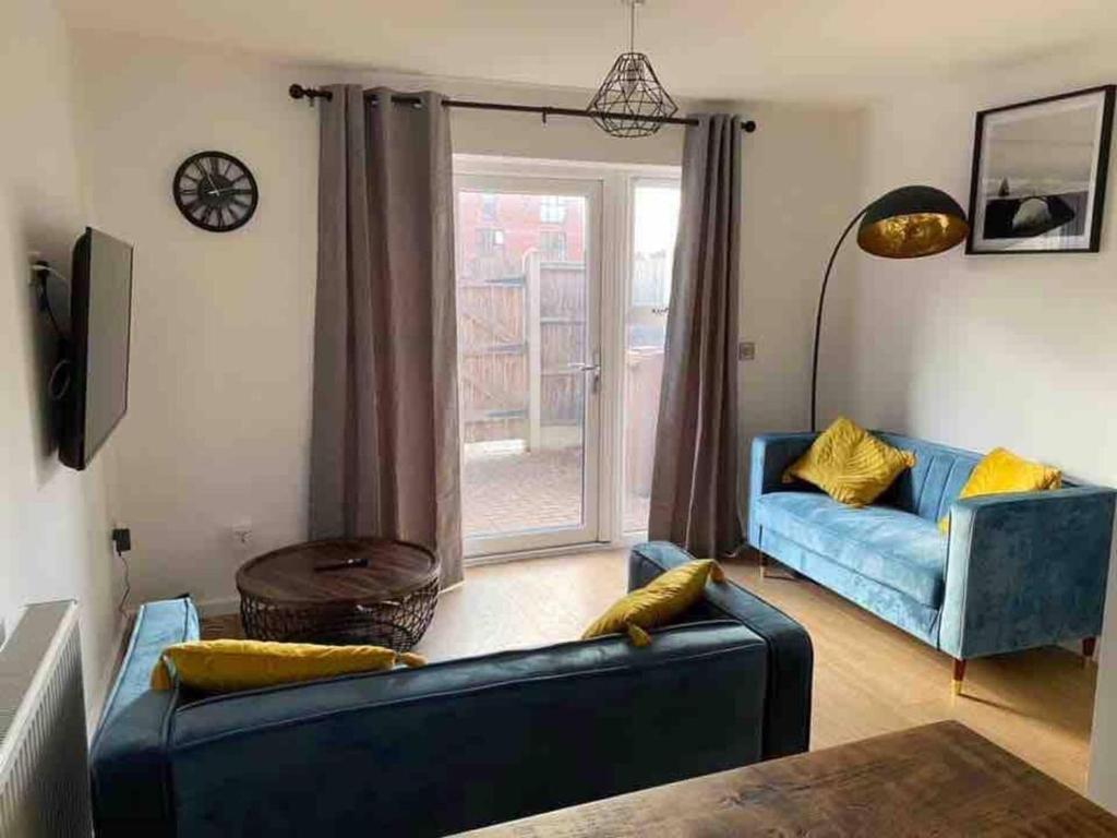 a living room with a blue couch and a window at Beautiful 4-Bed House in Lincoln- close to Centre in Lincoln