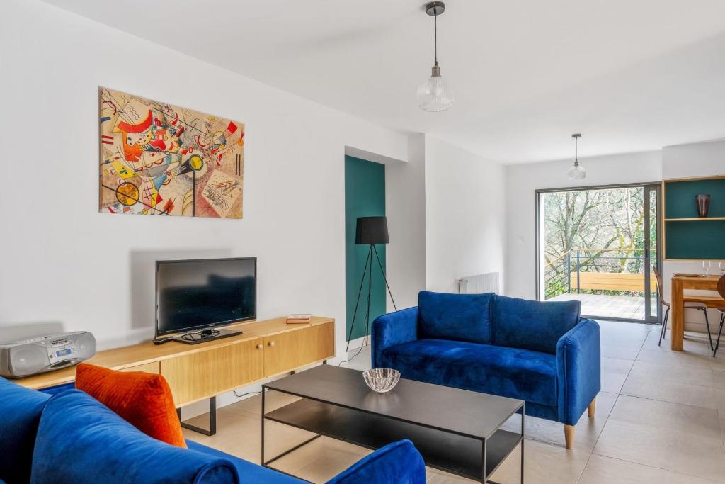 a living room with a blue couch and a tv at Appartement Bleuet - Welkeys in Arcachon
