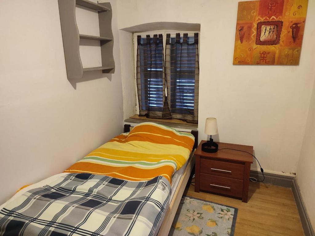 ein kleines Schlafzimmer mit einem Bett und einem Fenster in der Unterkunft Chambre Haut in Zilling