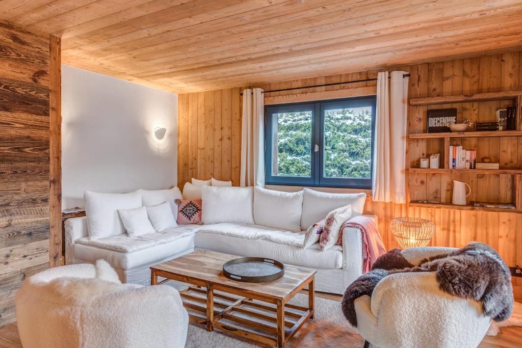 ein Wohnzimmer mit einem Sofa und 2 Stühlen in der Unterkunft Appartement Périade - Welkeys in Megève