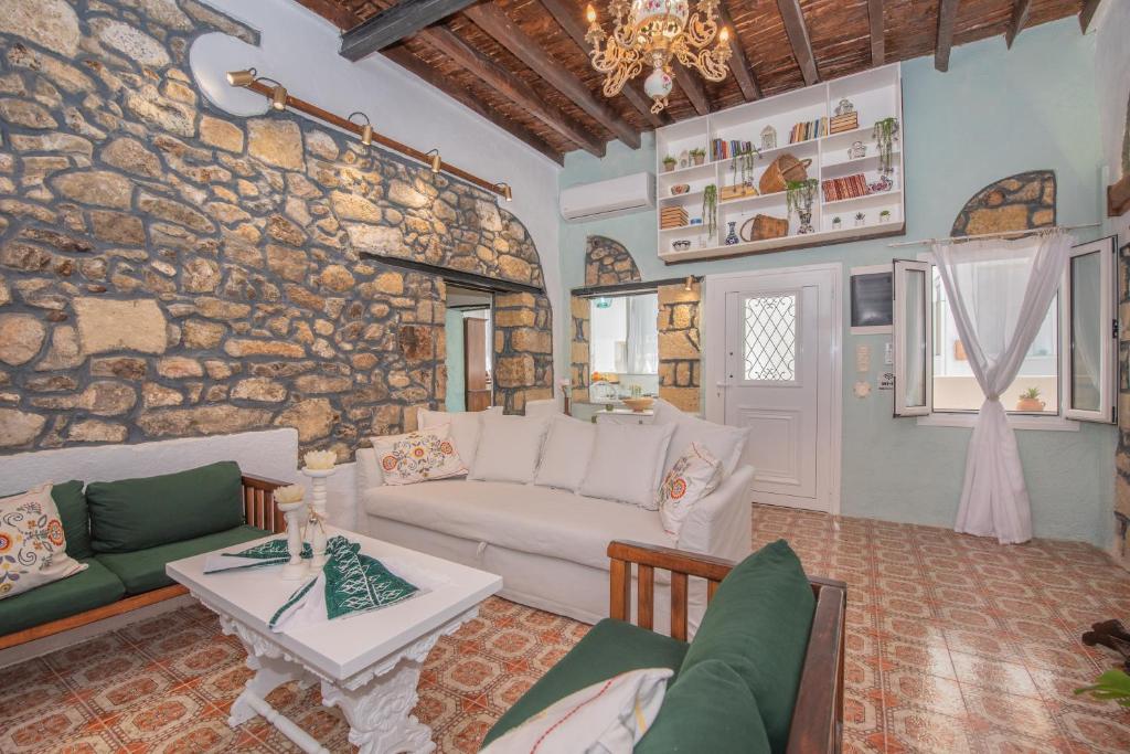 a living room with a couch and a stone wall at Philoxenia traditional house in Pastida