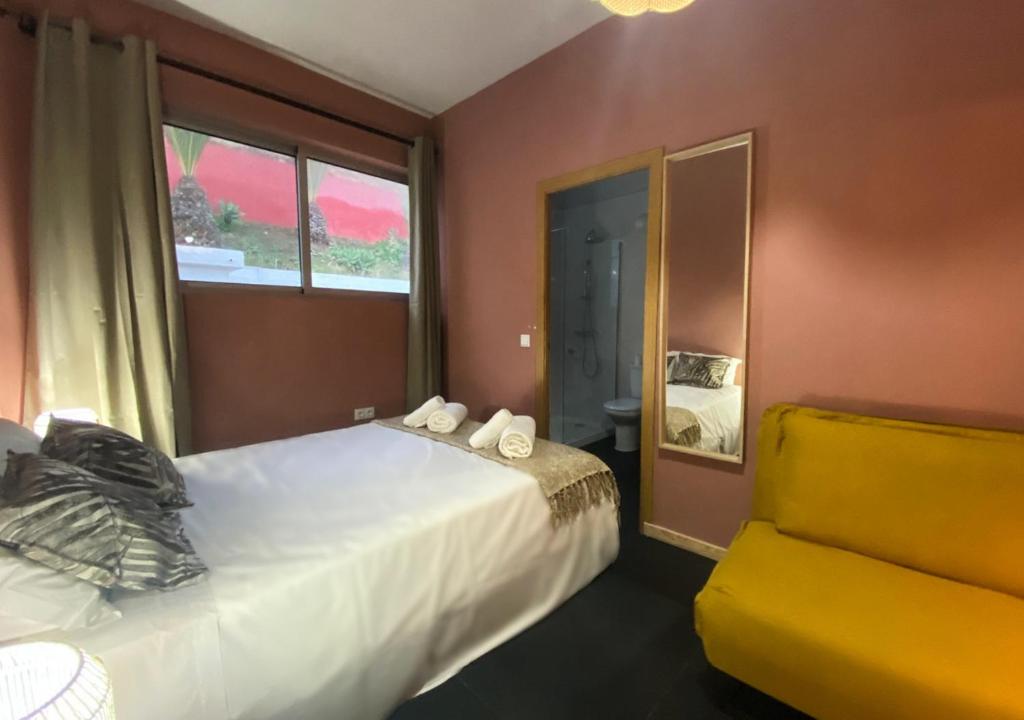 a bedroom with a bed and a yellow chair at Porto Santo Destination in Porto Santo