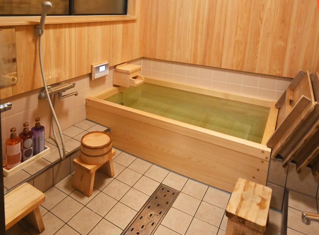 a bath tub in a bathroom with a toilet at Toshiharu Ryokan in Kyoto