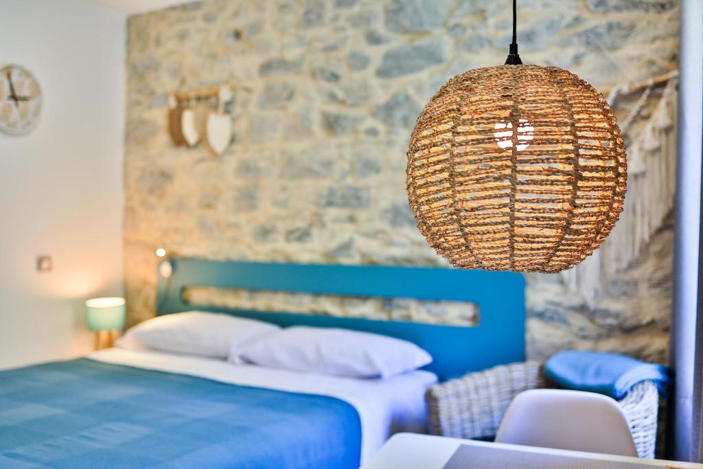 芒通的住宿－Le Vallaya Suites & Spa，一间卧室配有一张床和一个吊灯