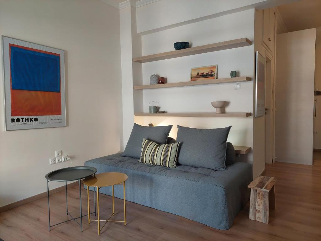 un soggiorno con divano blu e tavolo di Cholargos metro station 2 persons cozy studio. ad Atene