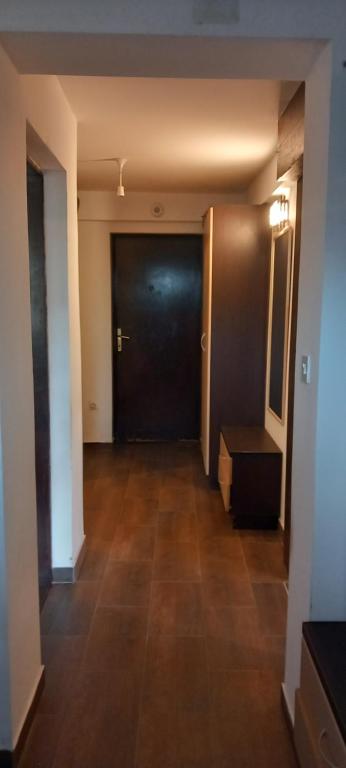 a hallway with a black door and a wooden floor at GM Place apartment 60 m2 in Gornji Milanovac