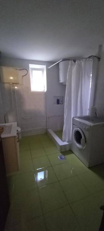 a bathroom with a washing machine and a window at GM Place apartment 60 m2 in Gornji Milanovac