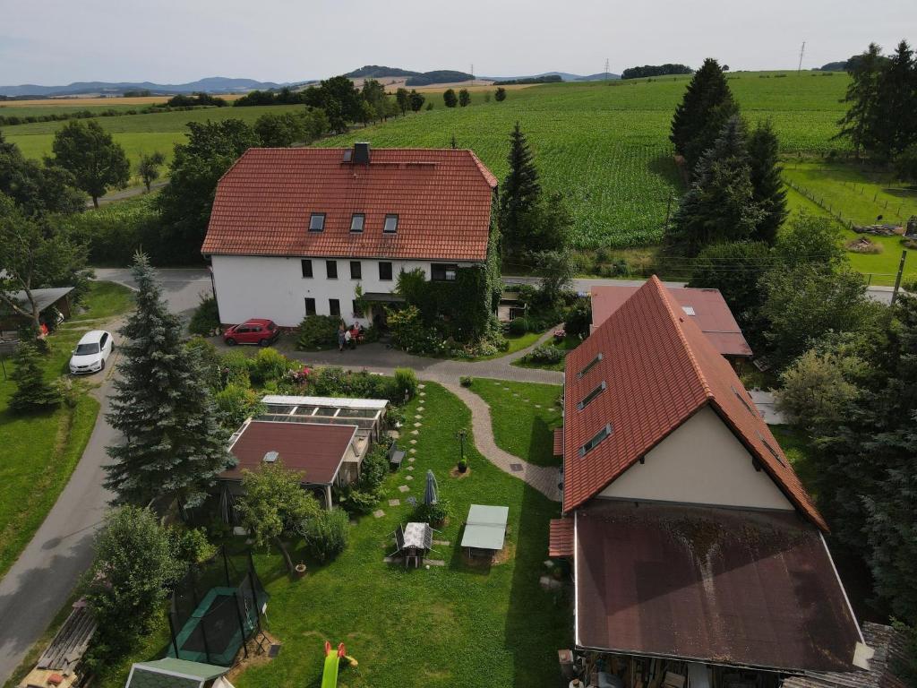 a white house with a red roof and a yard at Doppelzimmer Oybin in Herrnhut