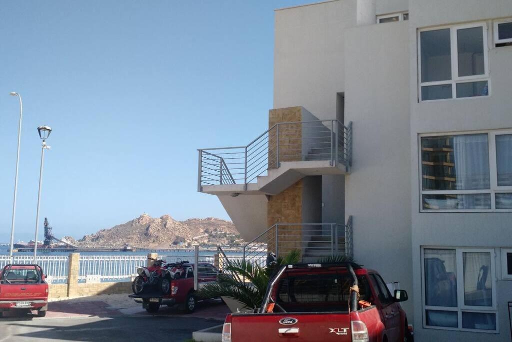 a building with two cars parked next to a building at Lindo duplex frente al Mar in Coquimbo