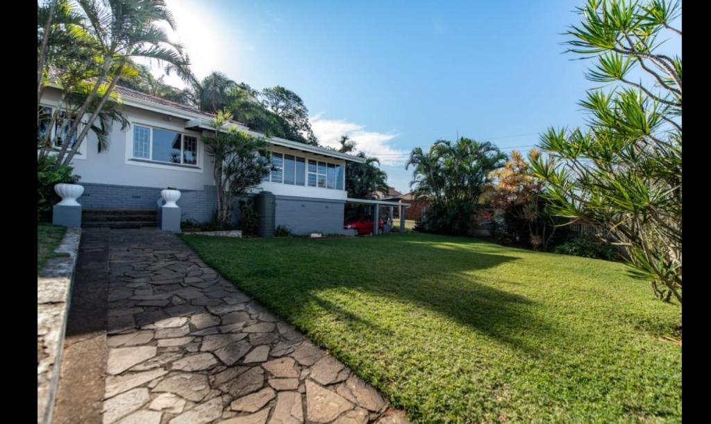 a house with a green lawn in front of it at Rose Holiday Home in Durban