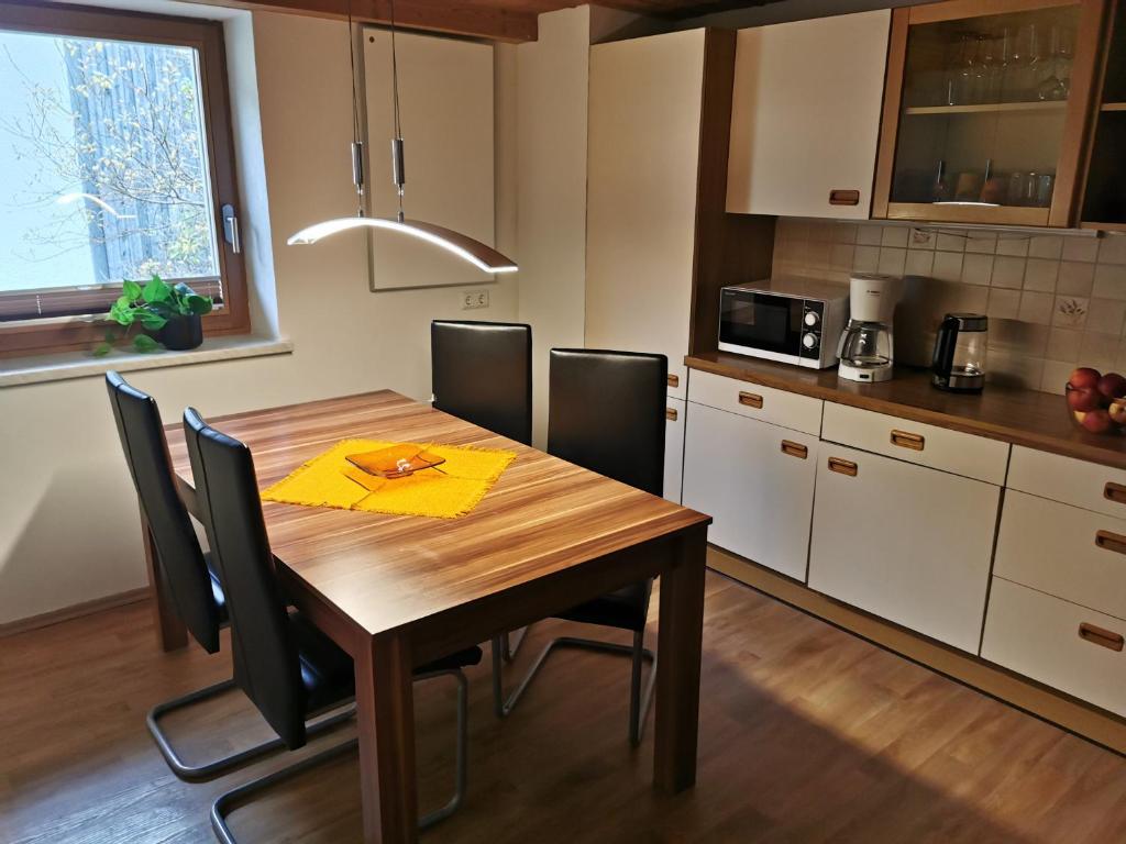 cocina con mesa de madera y sillas negras en Großzügige 80m² Wohnung in ruhiger Lage, en Vorderhornbach