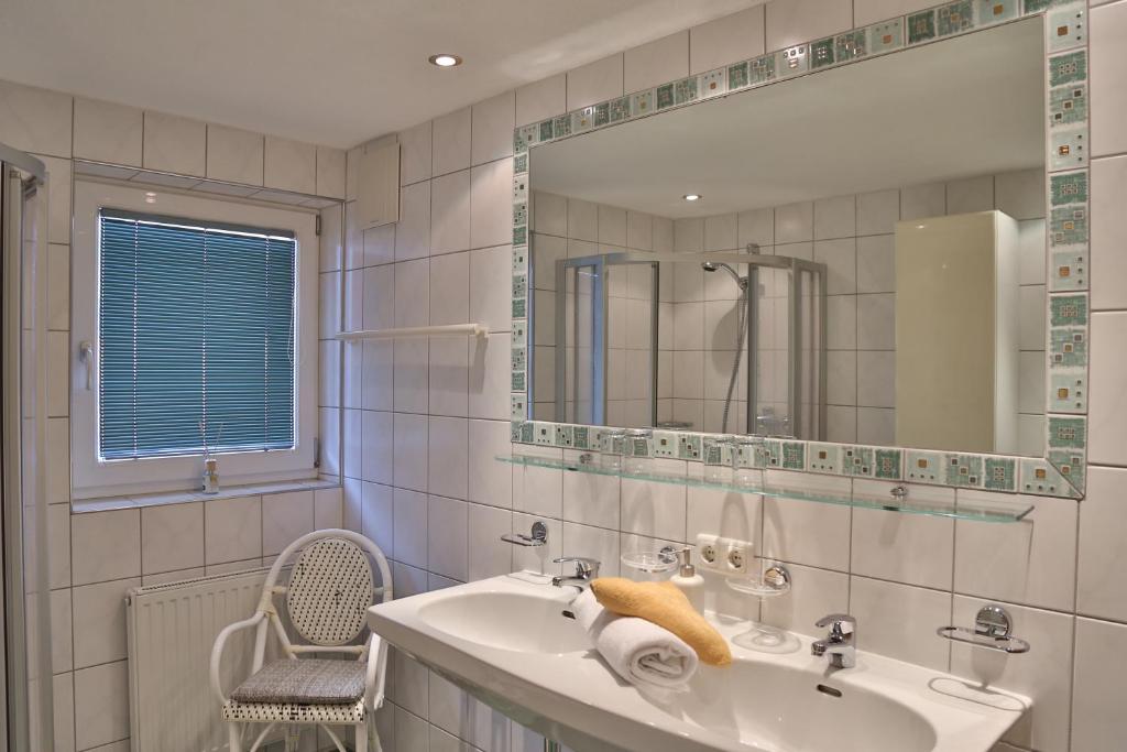 a bathroom with a sink and a mirror and a chair at Apart Altamira in Ischgl