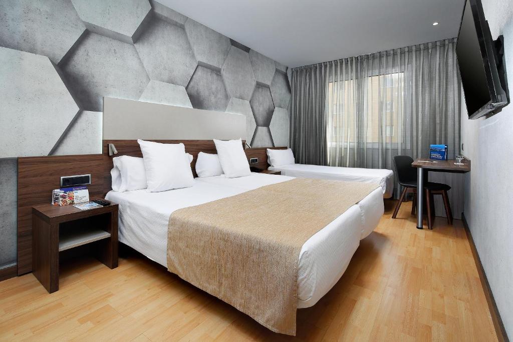 a hotel room with a large bed and a television at HCC Montblanc in Barcelona