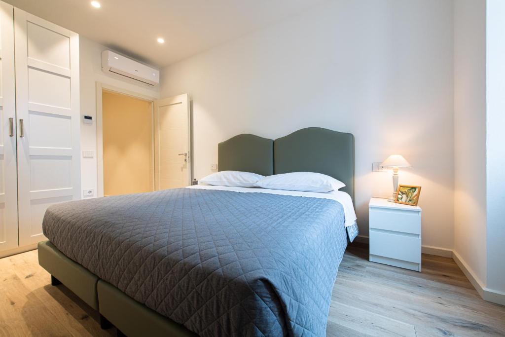 1 dormitorio con 1 cama con edredón azul y mesita de noche en Palazzo Chimelli en Pergine Valsugana